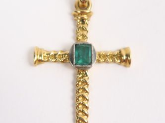 Pendentif en forme de croix en or, rehaussée d'une émeraude. Poids tel