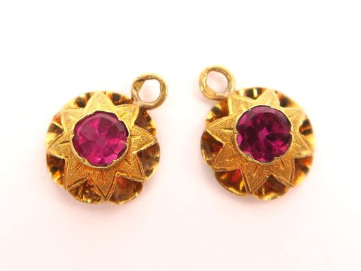 Deux breloques en or, serties de pierres roses. Poids tel : 1 g