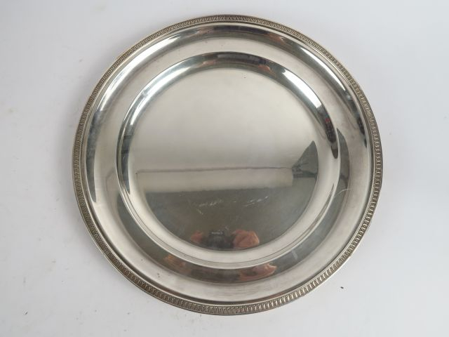 Plat rond à décor de frise de feuilles d'eau en métal argenté. SAGLIER