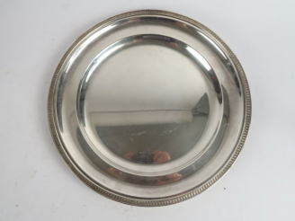 Vente aux enchères Plat rond à décor de frise de feuilles d'eau en métal argenté. SAGLIER