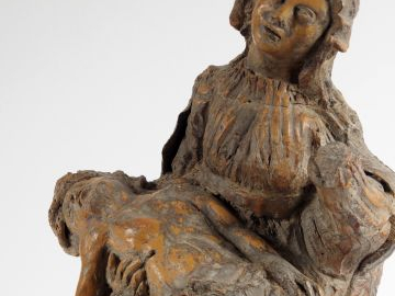 Vierge de Pitié en terre cuite, dos ébauché. Assise, elle porte le cor