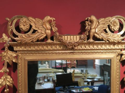 Grande glace de style Louis XVI en bois et stuc doré, à décor d'aigles