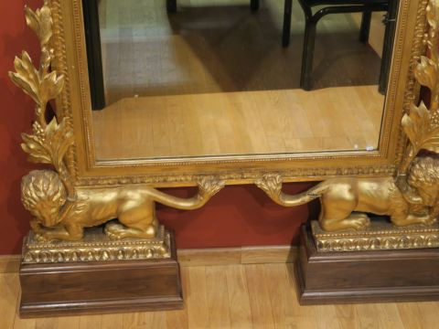 Grande glace de style Louis XVI en bois et stuc doré, à décor d'aigles