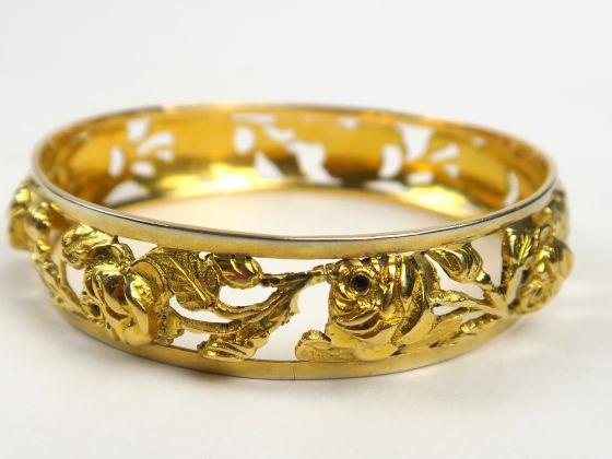 Bracelet jonc en or ajouré à décor de roses. Poids : 47,9 g