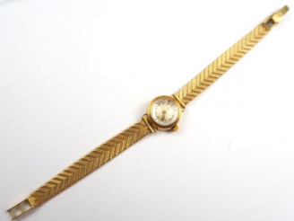 Vente aux enchères LIP. Petite montre de dame, boitier et bracelet en or. Poids tel : 16,