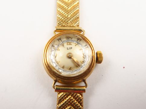 LIP. Petite montre de dame, boitier et bracelet en or. Poids tel : 16,
