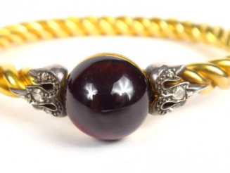 Vente aux enchères Bracelet  jonc en or torsadé, orné d'une pierre rouge cabochon, et de 