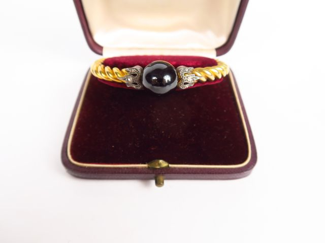 Bracelet  jonc en or torsadé, orné d'une pierre rouge cabochon, et de 
