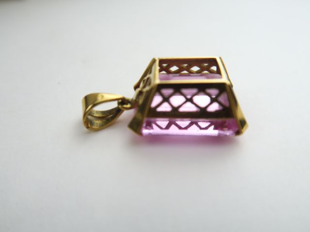 Pendentif retenant une pierre rose (topaze ?). Monture en or. Poids te