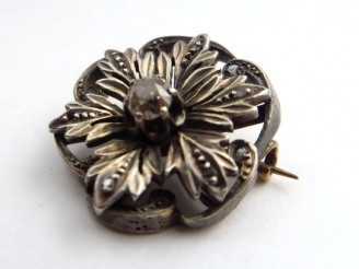 Vente aux enchères Broche ronde en or blanc, à décor de fleurs, orné en son centre  d’un 