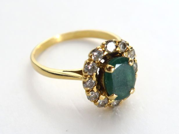 Bague marguerite en or, sertie d'une émeraude dans un entourage de dia