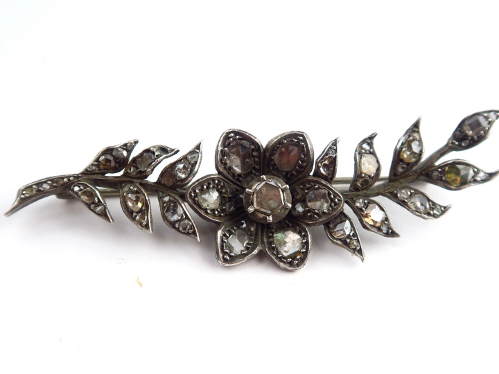 Broche en argent en forme de branchage fleuri serti de roses.  Poids :