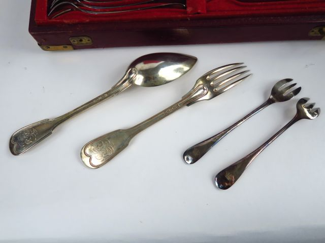 12 couverts en argent étranger, modèle au filet. Chiffrés. On y joint 