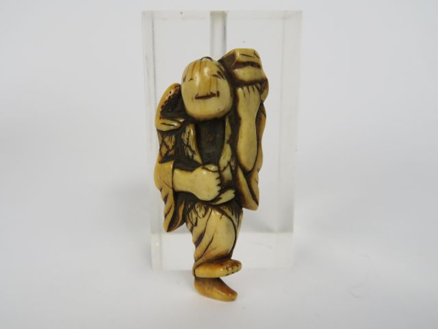 Netsuke en ivoire rehaussé de brun, représentant Gama-sennin debout su