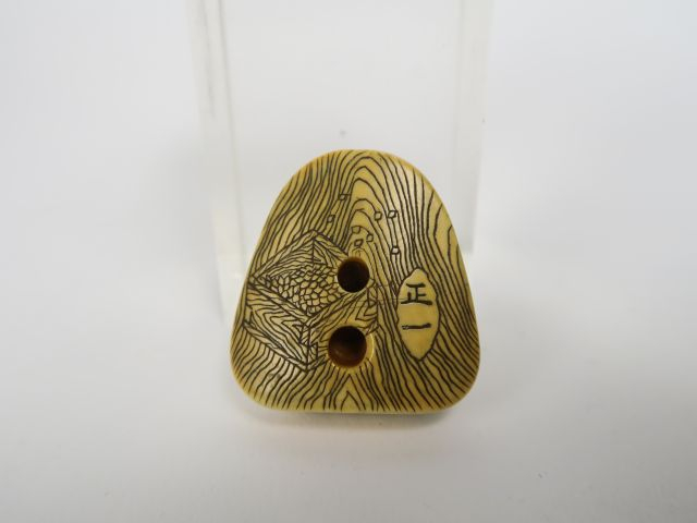 Netsuke en ivoire et rehauts bruns représentant un masque d’Okame, le 
