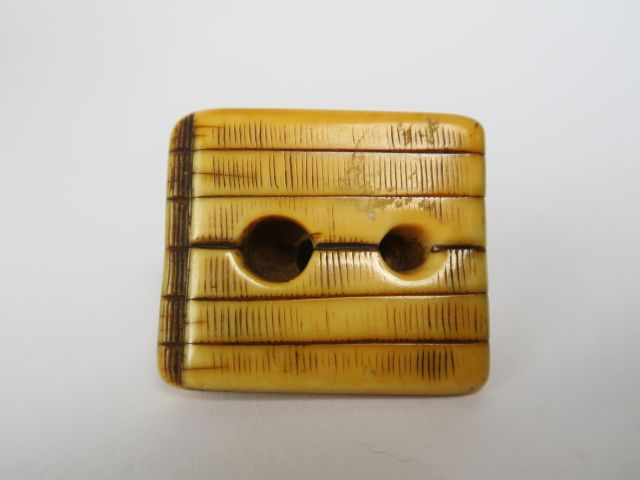 Netsuke en ivoire et rehauts bruns représentant un homme endormi sur u