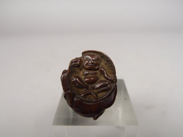 Netsuke en bois représentant Shoki plaquant au sol un grand chapeau so