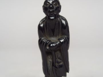 Netsuke en ébène représentant le sennin Tekkai debout, appuyé sur son 