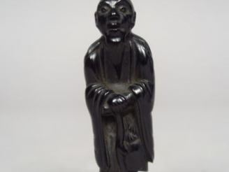 Vente aux enchères Netsuke en ébène représentant le sennin Tekkai debout, appuyé sur son 