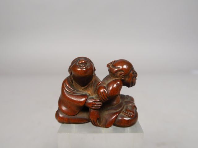 Netsuke en bois représentant un aveugle pratiquant un amma, massant le