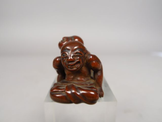 Netsuke en bois représentant un aveugle pratiquant un amma, massant le