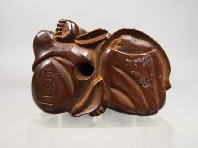 Netsuke en bois représentant un aveugle pratiquant un amma, massant le