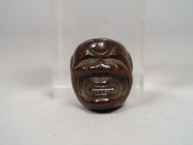 Netsuke en bois sculpté en forme de masque de Beshimi. Signé Deme Jôma