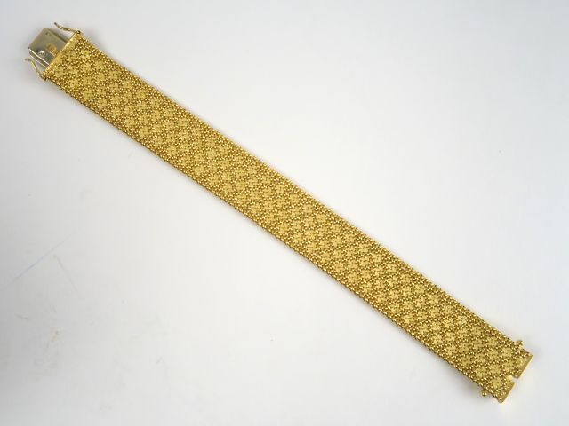 Bracelet maille souple en or, à décor de fleurs stylisées. Poids : 42,