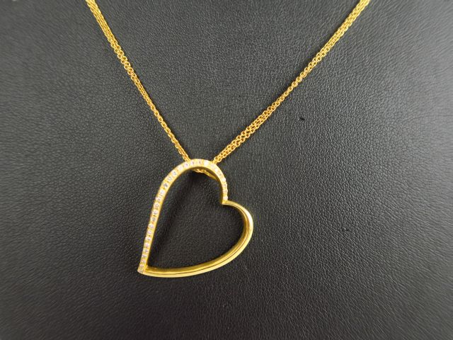 Chaine en or et son pendentif en forme de cœur, en or serti de roses. 