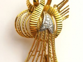 Vente aux enchères Broche en or figurant un nœud stylisé, rehaussé de petits diamants. Po