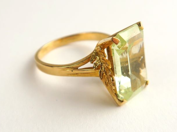 Bague ornée d'une pierre verte, belle monture en or à décor de plumes 