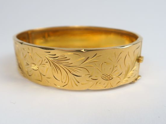 Bracelet manchette en or, à décor gravé de fleurs et de feuillage. Poi