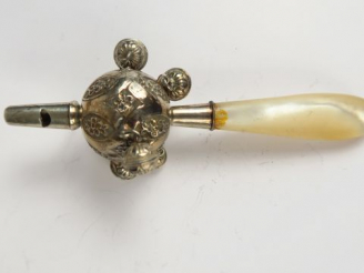 Vente aux enchères Hochet siffleur XIXe  en argent ciselé et repousssé à décor de fleurs 