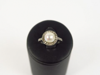 Vente aux enchères Bague 1900 en or blanc ornée d'une perle entourée de roses.  3 g