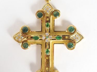 Importante croix en or jaune montée en pendentif, ornée de 12 émeraude