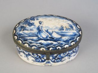 Vente aux enchères 	Boite ovale en faïence de Delft, à décor de jeune femme sur fond de p