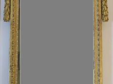 Vente aux enchères 	Grande glace de cheminée Louis XVI en bois sculpté et doré, à décor d