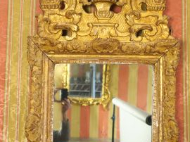 Vente aux enchères Glace Louis XV en bois sculpté et doré, à décor de rocailles et de feu