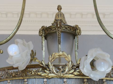 Grand lustre de style Louis XVI en bronze doré, à décor de têtes de bo