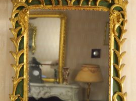 Vente aux enchères 	Glace Louis XV en bois sculpté et doré, à décor de branchage, surmont