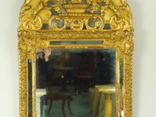 Miroir XVIIIème à parcloses en bois et stuc doré, fronton ajouré à déc