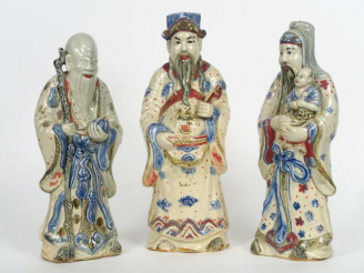 Vente aux enchères Trois statuettes en faïence émaillée en bleu sur fond crème et rehauss