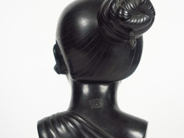 Buste de jeune femme en bronze à patine brune.  Signature illisible. H