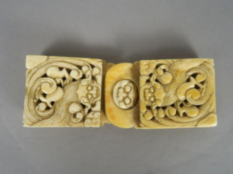 Vente aux enchères Boucle de ceinture en ivoire, à décor de lions bouddhiques affrontés. 