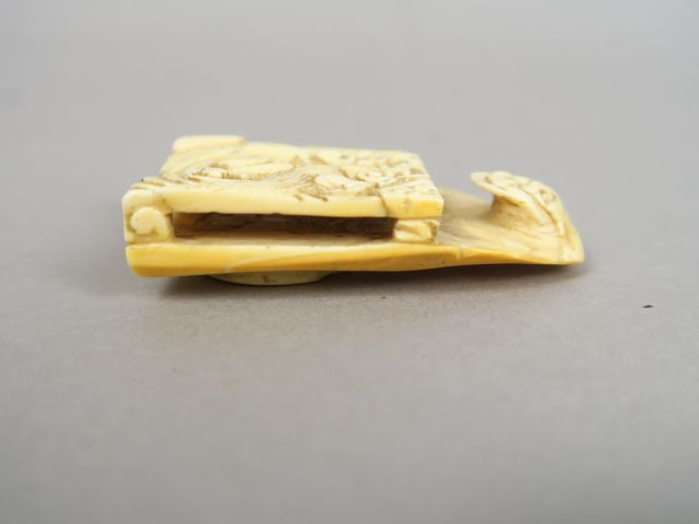 Boucle de ceinture en ivoire, à décor de lions bouddhiques affrontés. 