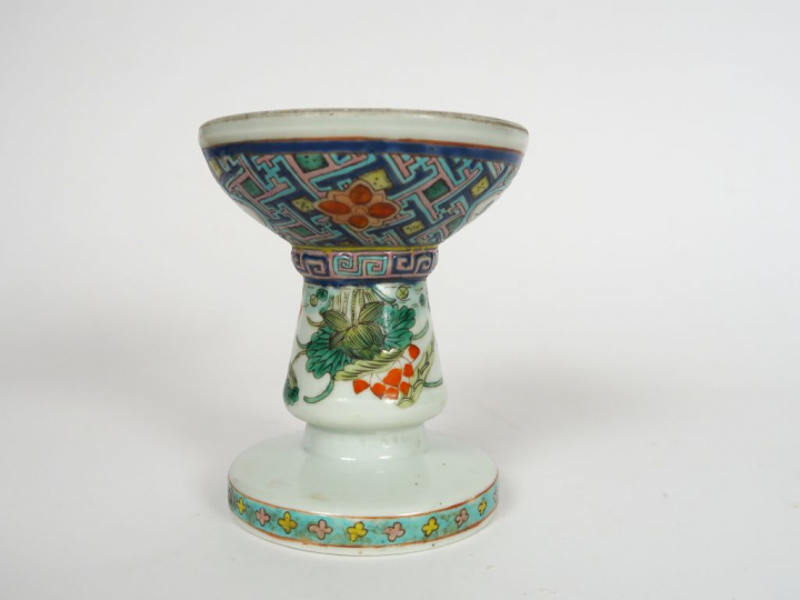 Coupe sur piédouche en porcelaine et émaux polychromes, à décor de fle