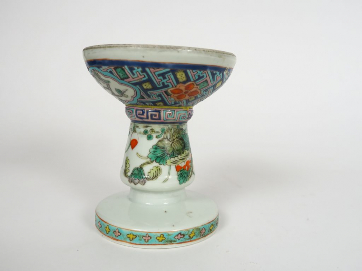 Coupe sur piédouche en porcelaine et émaux polychromes, à décor de fle
