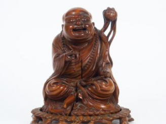 Vente aux enchères Statuette en bois représentant un Lohan assis, tenant un rosaire et un