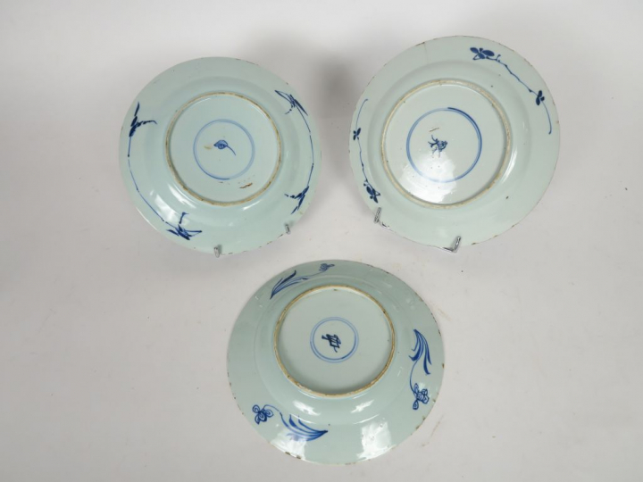 Ensemble de trois assiettes en porcelaine bleu blanc, décor de composi