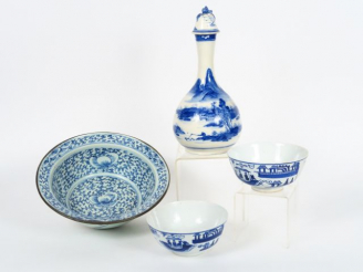 Vente aux enchères Bouteille en céramique bleu sur fond crème, décor de paysage lacustre.